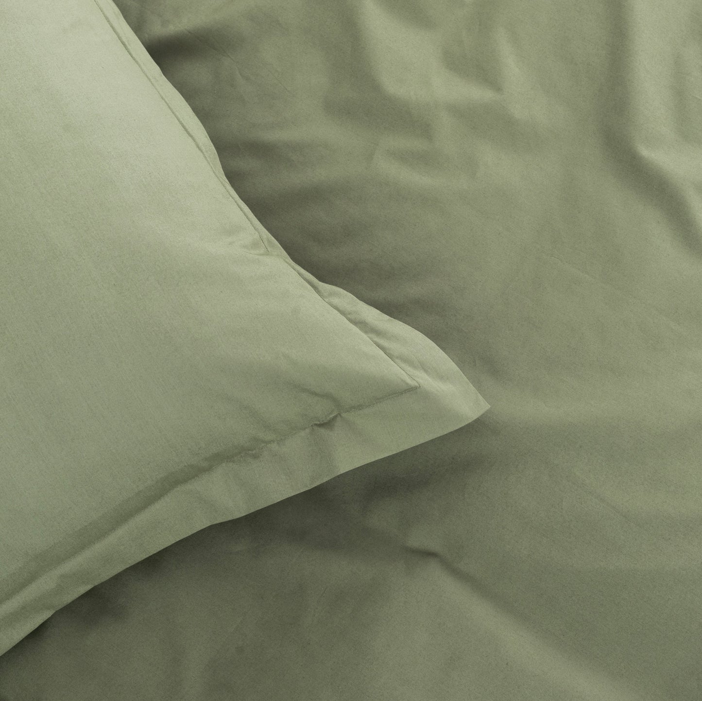 Close-up of green bedding with a pillow