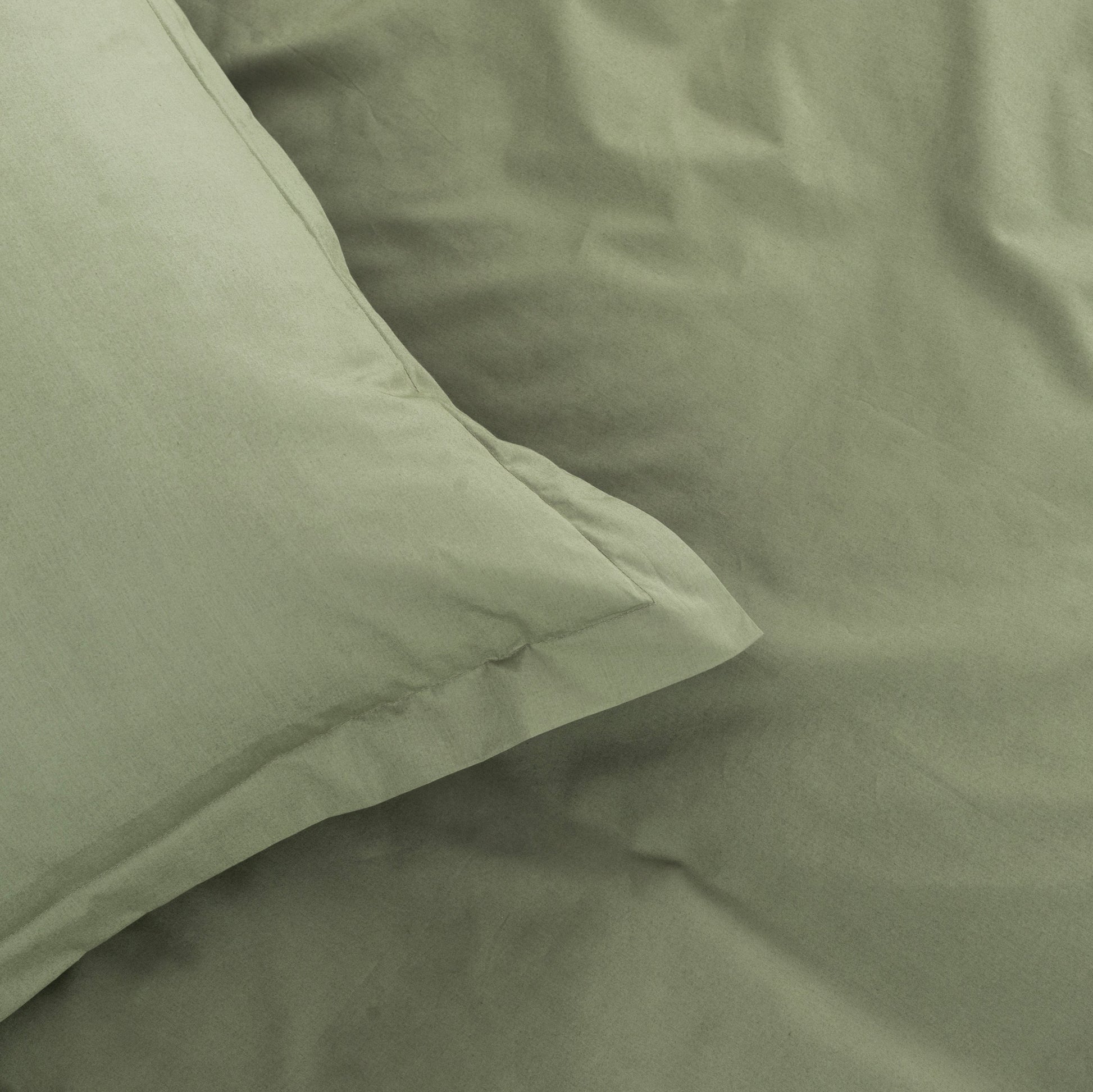 Close-up of green bedding with a pillow