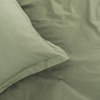 Close-up of green bedding with a pillow