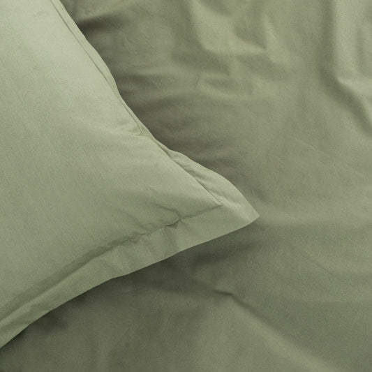 Close-up of green bedding with a pillow